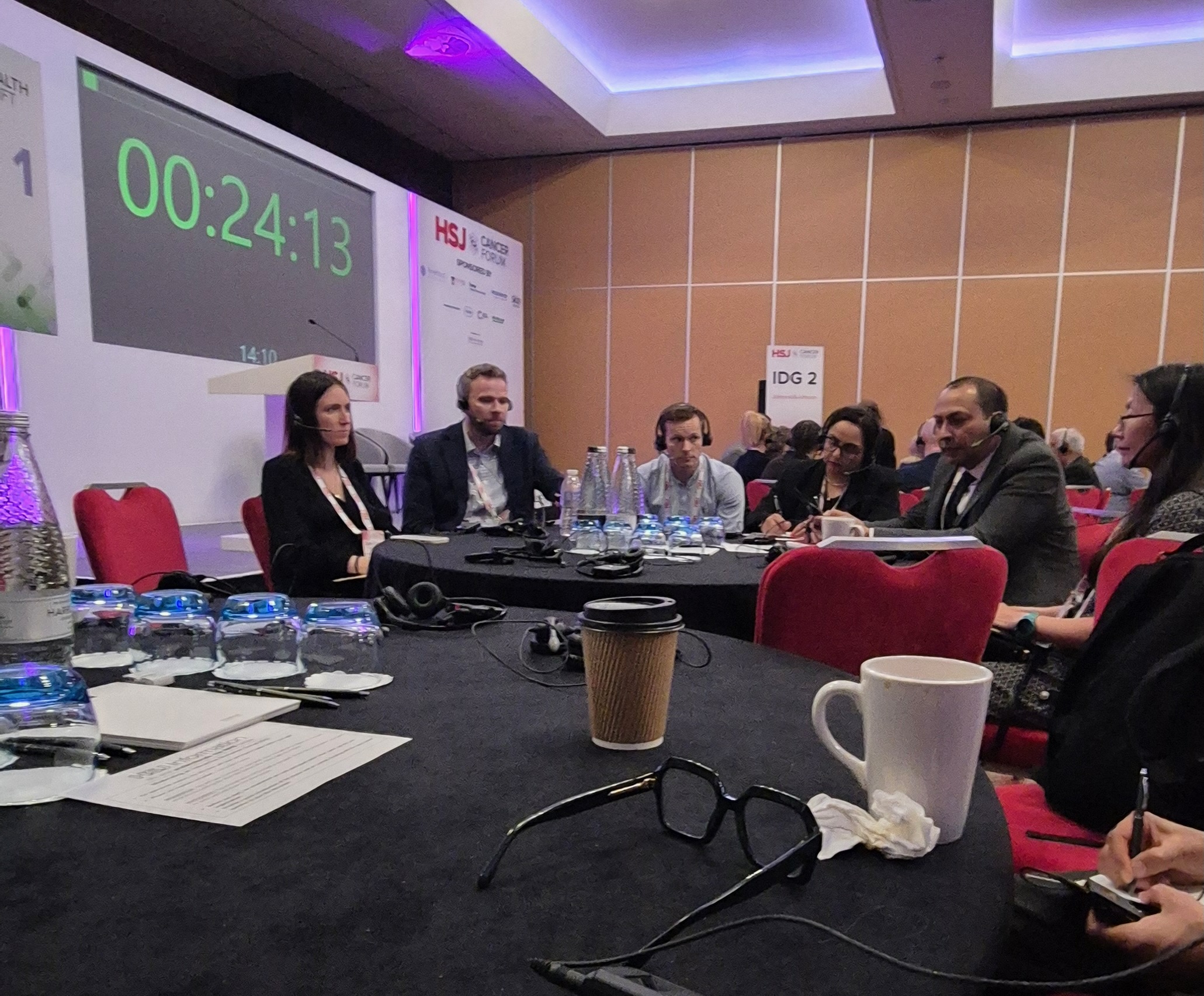 Six people are sat around a table having an interactive discussion.