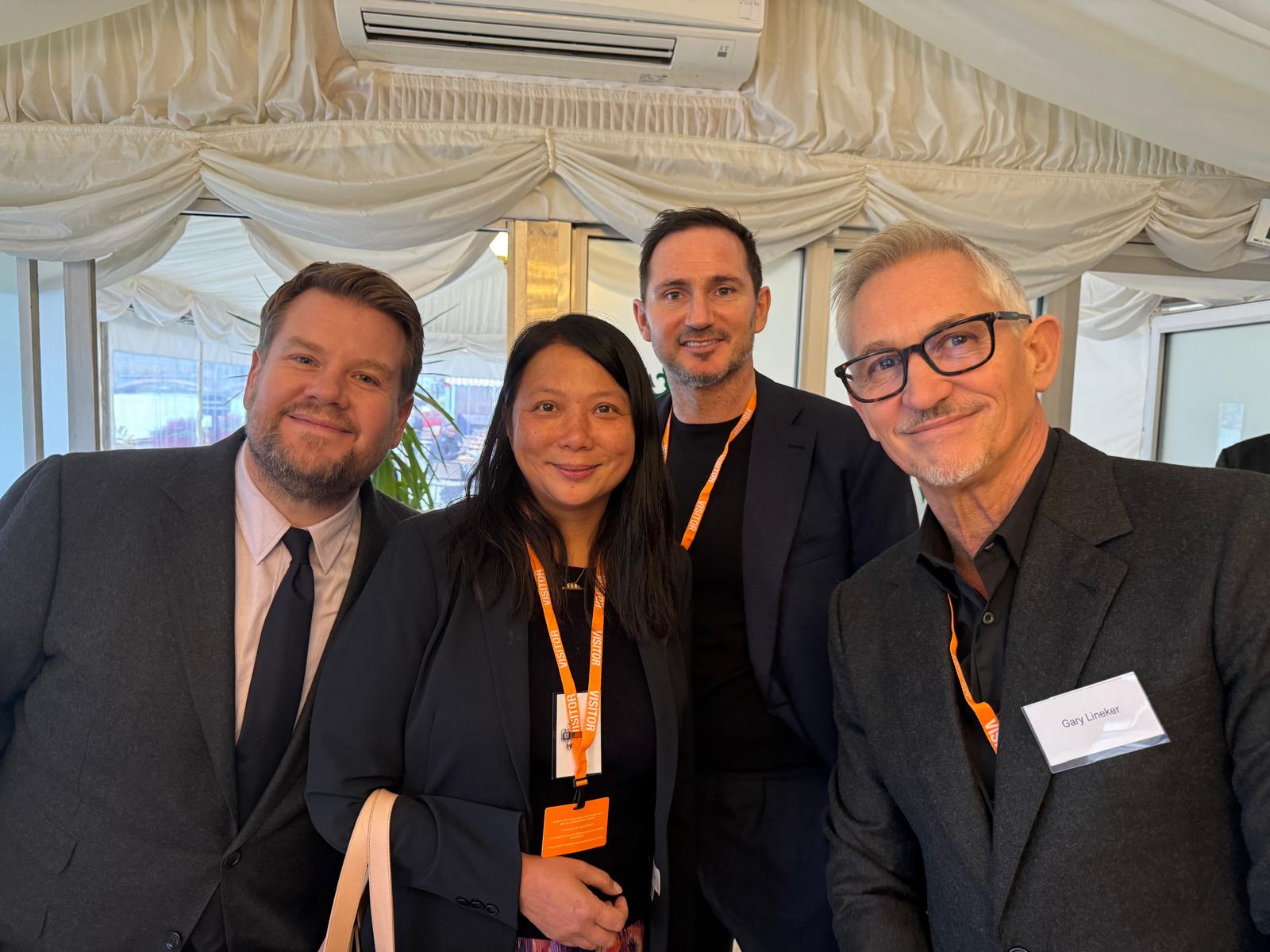 Angela Wong is standing with James Corden, Frank Lampard and Gary Lineker