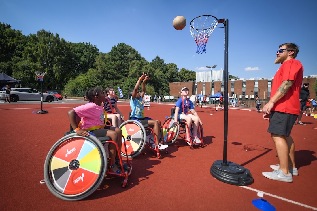 A group of people in wheelchairs is playing basketball.