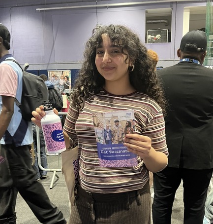 student holding HPV Vaccine merch