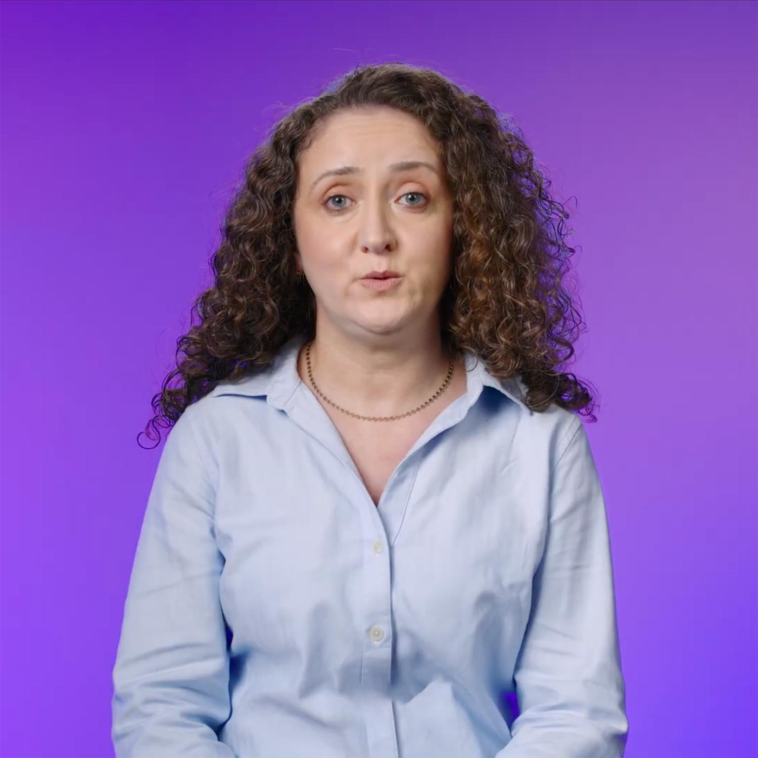 A portrait photo of a lady looking ahead against a purple background
