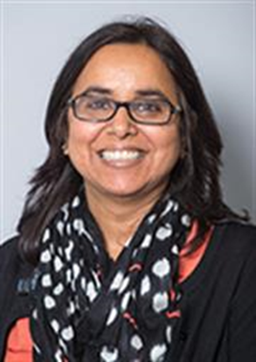 The image is of an asian lady wearing glasses and a blue and white scarf. She is smiling and looking towards the camera.