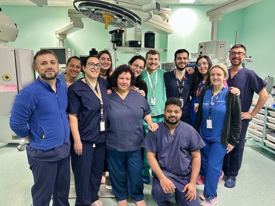 A team of clinicians in medical uniform is pictured in an operating theatre.