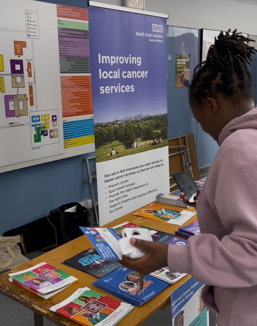 a member of the community taking pictures of the leaflets on the stall