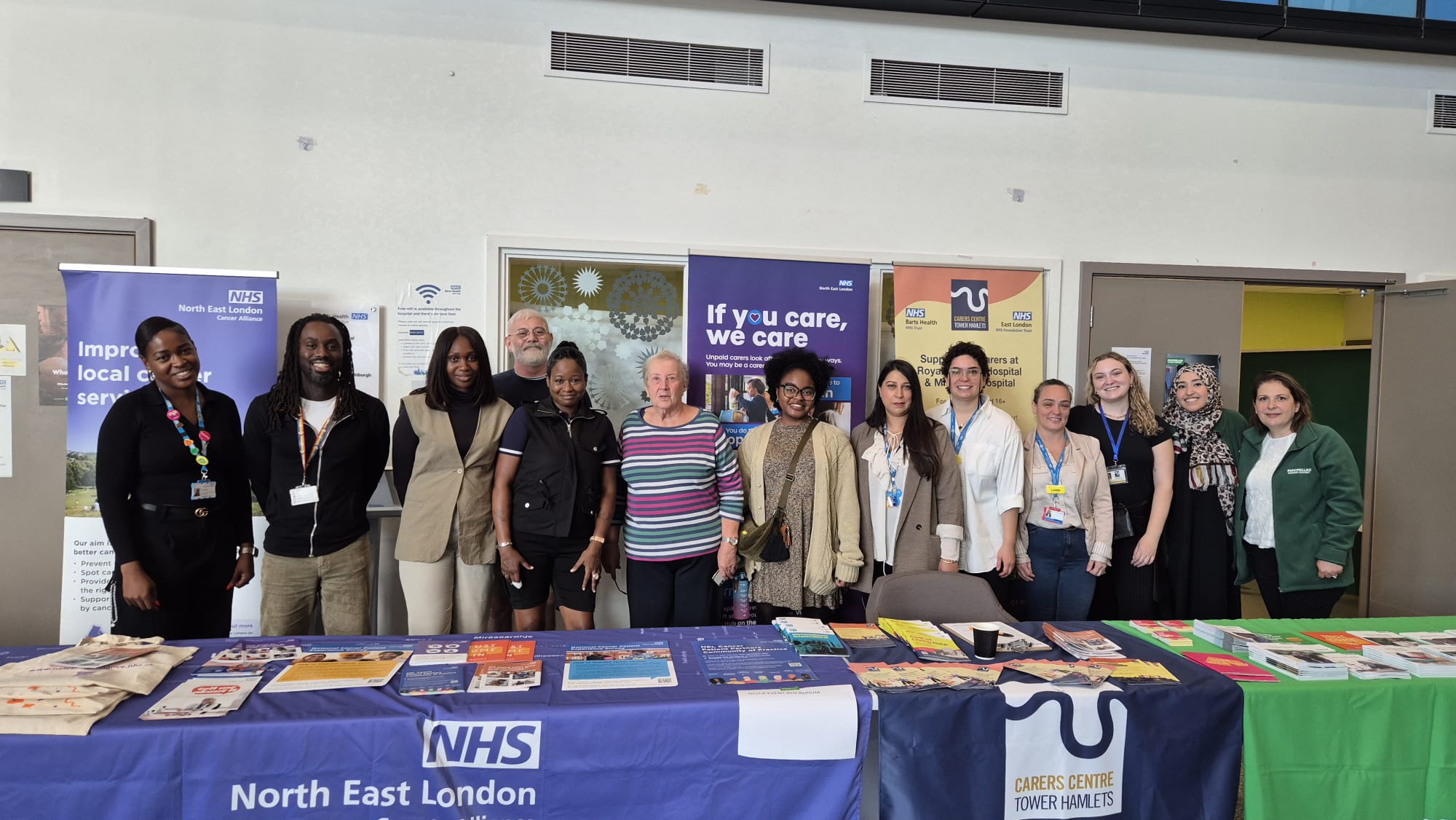 a group of health professionals standing behind information stalls 