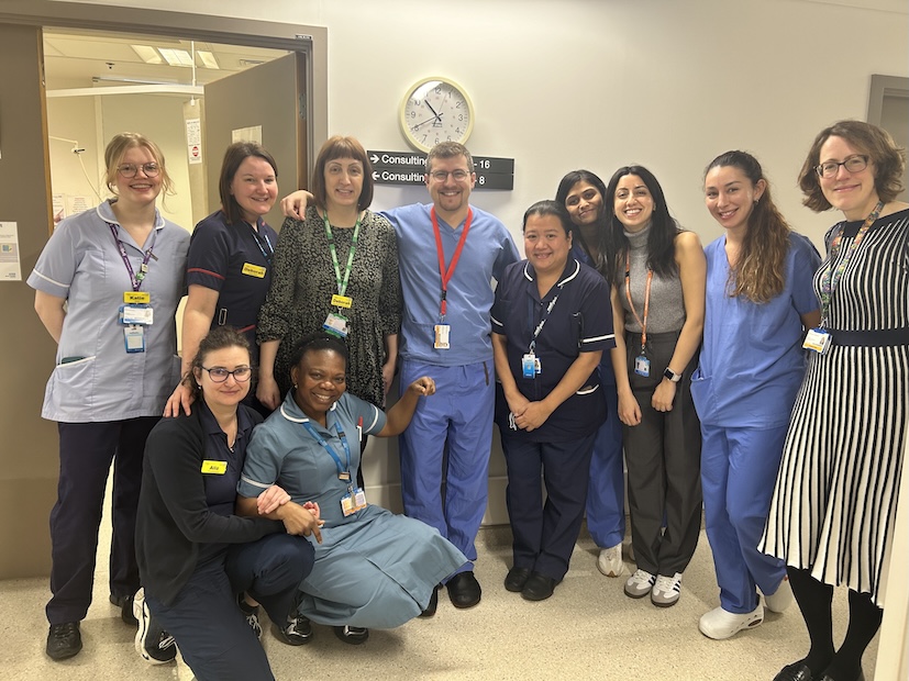 A team of clinicians in medical uniform is pictured in a hospital.