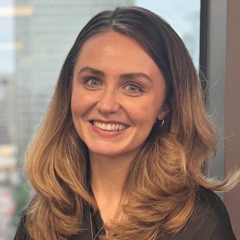 A profile photo of a lady with brown hair wearing a black top.