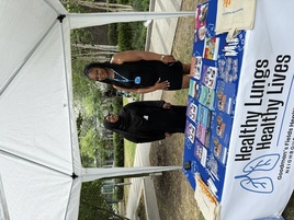 two ladies standing behind a table with leaflets and flyers 