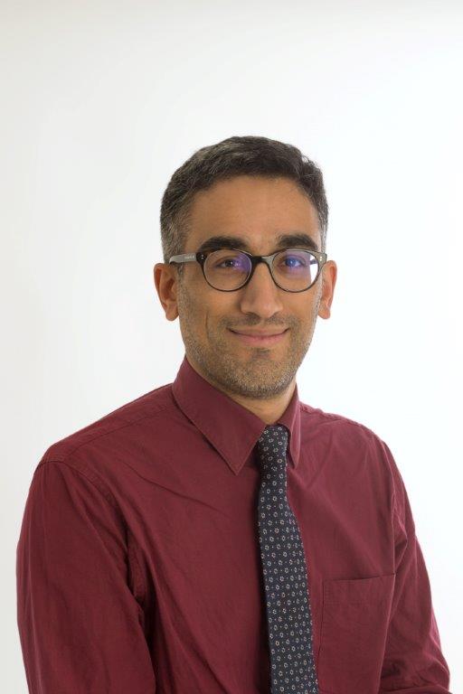 An image of Professor Prabhakar Rajan wearing a dark red shirt and glasses.