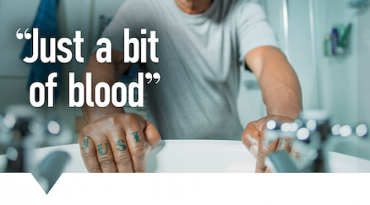 A man looking in a mirror in a bathroom which a concerned expression on his face. Text reads 'Just a bit of blood'. There is also the NHS logo. A message at the bottom reads 'Blood in your pee just once? Contact your GP practice'