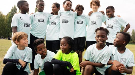 The image is of a team photo of a boy's football team, wearing white shirts