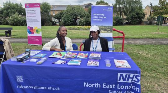 two people sitting behind a stall with leaflets