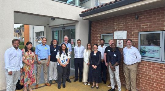A large group of people standing outside a building facing the camera.