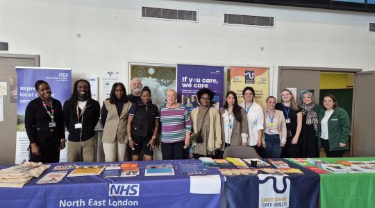 A group of people behind information stalls 