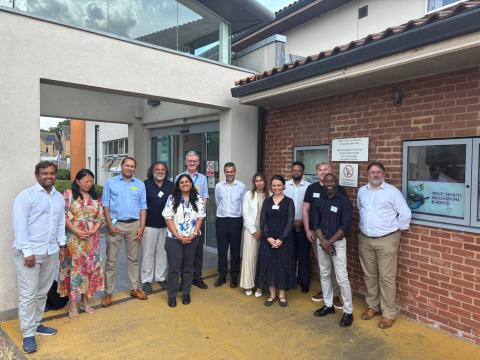 A large group of people standing outside a building facing the camera.