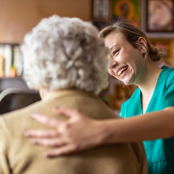 nurse holding old person's back