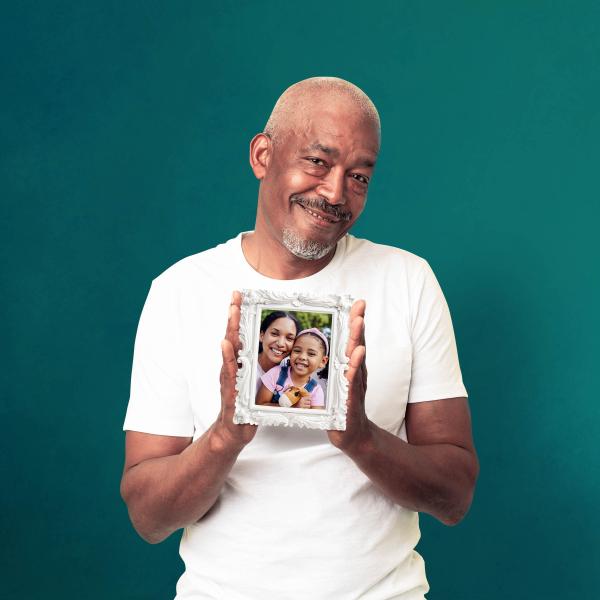 A black man is holding a framed picture of a mother and child